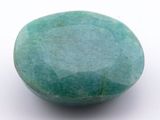 une pierre vert turquoise posée sur une surface blanche, avec un fond blanc