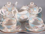 a tea set on a tray with a cup and saucer
