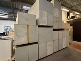 many white refrigerators stacked on top of each other in a warehouse