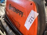 an orange and black welding machine sitting on top of a pile of wires