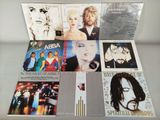 various cd ' s of various albums and albums on a glass table