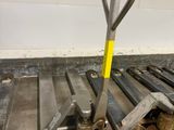 a fork and a pallet on the floor next to a pile of wood