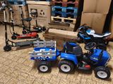 a blue toy tractor with a trailer and a scooter next to it