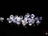 a bunch of purple and white diamonds on a black surface