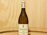une bouteille de vin posée sur un tonneau