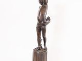 bronze statue of a boy holding a basketball ball on a pedestal