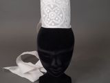 une tête de mannequin noire coiffée d'un chapeau blanc
