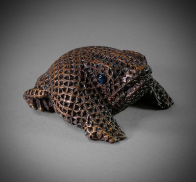 a close up of a figurine of a turtle on a gray surface