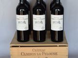 three bottles of red wine in a wooden box on a table