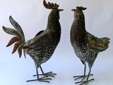 deux poulets en métal placés côte à côte sur une surface blanche