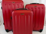 trois valises rouges posées sur une surface blanche