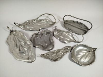 several silver metal objects are arranged on a white surface