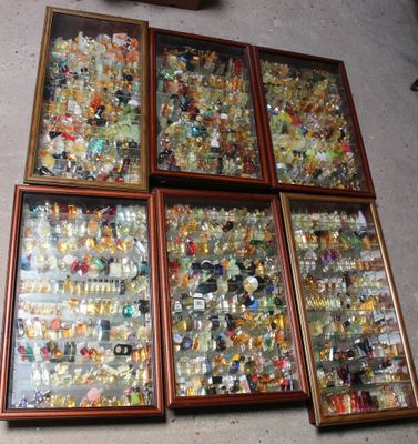 four wooden frames filled with assorted glass items sitting on the floor