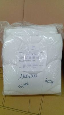 Deux rouleaux de papier toilette, emballés dans du plastique, sont posés sur une table.