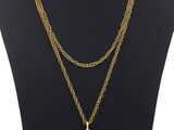 un mannequin portant une chaîne en or et un pendentif orné d'une pierre rose