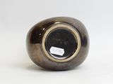 an image of a black and gold vase sitting on a white surface