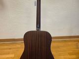 a close up of a guitar on a stand on a hard wood floor