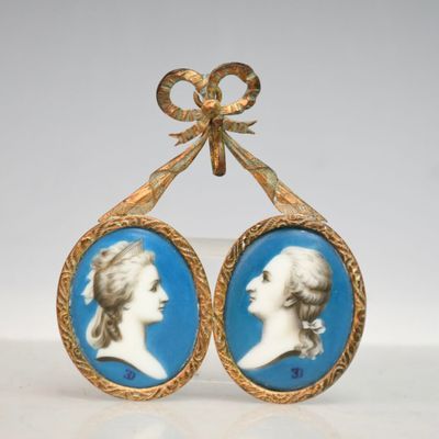 un gros plan sur une paire de boucles d'oreilles ornées de l'image d'une femme