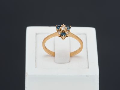 a close up of a gold ring with blue and white stones