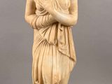 une statue ancienne représentant une femme tenant un bébé dans ses bras