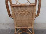 a wicker chair that is sitting in front of a white wall