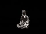 the buddha statue is sitting on a black surface in the dark