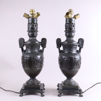 paire d'urnes antiques en bronze, munies d'anses et posées sur des socles