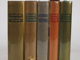 quatre livres sont alignés sur une surface blanche