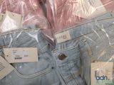 several pairs of jeans are wrapped in plastic bags on a table