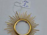 a gold plated sunburst on a white surface with a price tag
