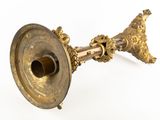 a brass candle holder on a white background