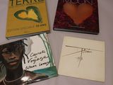 Trois livres sont posés sur une table, avec un mot devant eux.