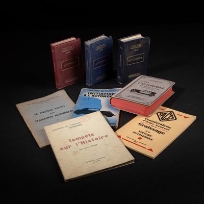 Plusieurs livres sont disposés sur une surface noire, sur fond noir.