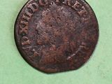 a close up of an old coin on a green surface