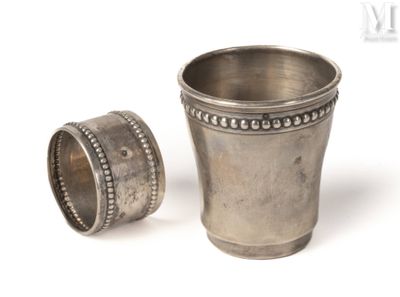 une coupe en argent et une bague en argent sur fond blanc