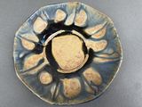 a blue plate with a yellow center on a gray surface
