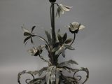 a metal vase with flowers on it on a table