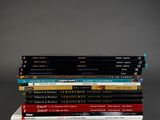 many books stacked on top of each other on a table