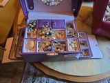 a purple box filled with lots of jewelry on a table