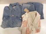 two pairs of blue and white shirts on display on a table
