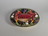 une assiette posée sur une table, sur laquelle se trouve un crabe