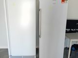 two white refrigerators sitting next to each other in a room