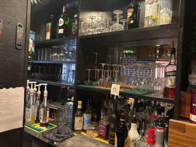un bar avec plein de bouteilles et de verres sur les étagères