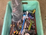 a plastic container filled with assorted tools on the floor