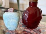 two vases sitting on a glass table next to each other