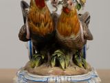 a figurine of two roosters on a table