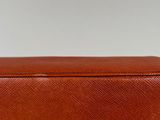 a close up of a brown leather box on a white surface