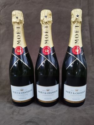 trois bouteilles de champagne posées sur une table