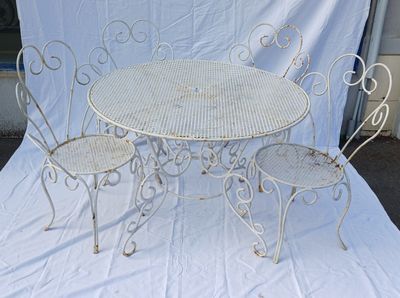 a white table and four chairs sitting on a white sheet