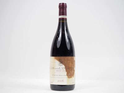 une bouteille de vin rouge posée sur une table blanche